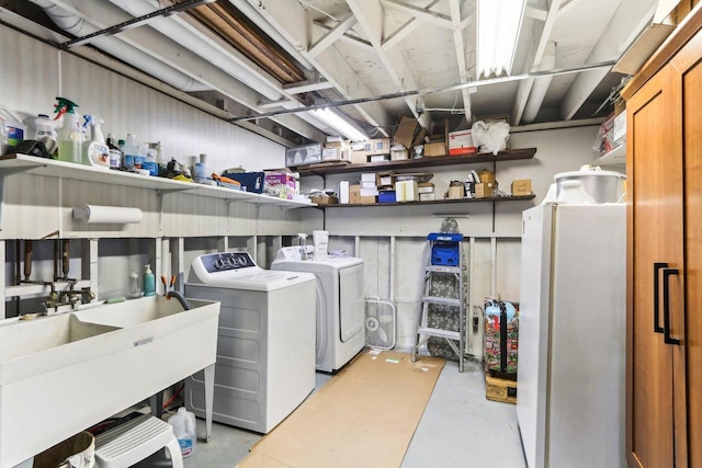 clothes washing area featuring laundry area, a sink, and separate washer and dryer