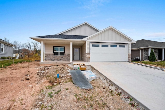 view of front of house with stone siding, driveway, a porch, and an attached garage