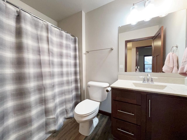 full bathroom with toilet, curtained shower, wood finished floors, and vanity