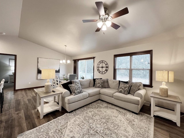 living room with vaulted ceiling, ceiling fan with notable chandelier, wood finished floors, and baseboards