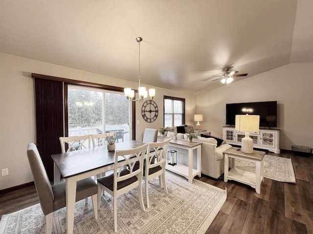 dining room with lofted ceiling, dark wood-style flooring, baseboards, and ceiling fan with notable chandelier