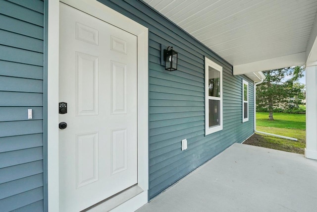 view of exterior entry featuring covered porch