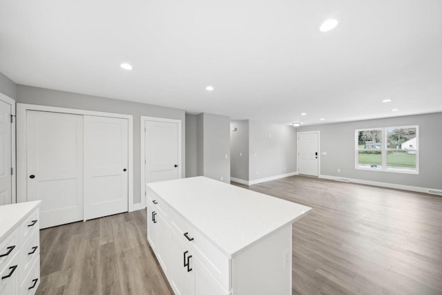 kitchen with light wood-style floors, recessed lighting, light countertops, and a kitchen island