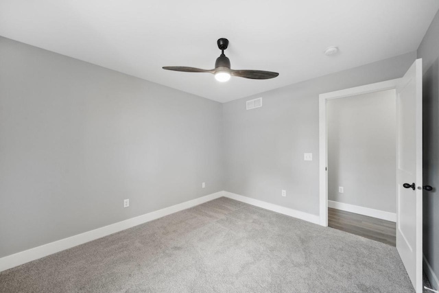 empty room featuring ceiling fan, carpet floors, visible vents, and baseboards