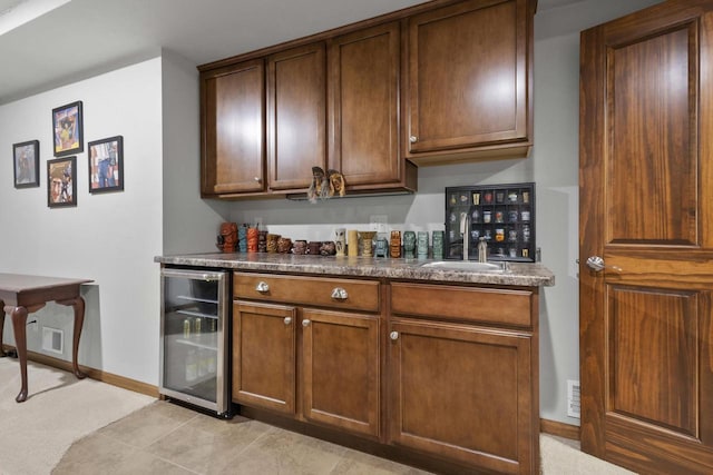 bar featuring wet bar, beverage cooler, a sink, and baseboards