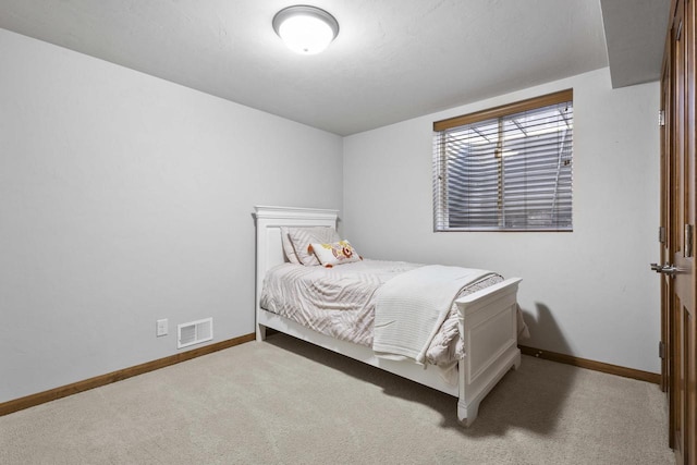 carpeted bedroom featuring visible vents and baseboards