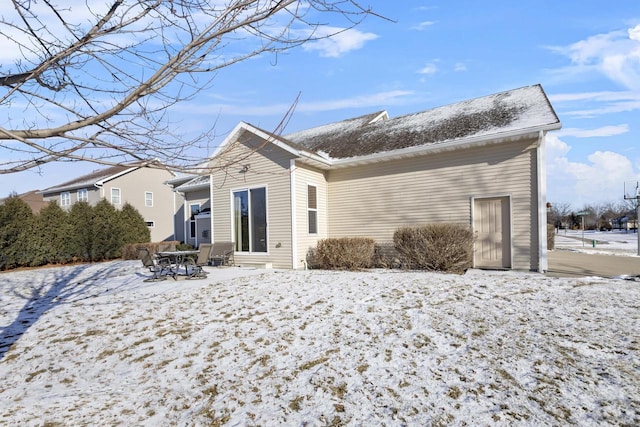 view of snow covered rear of property