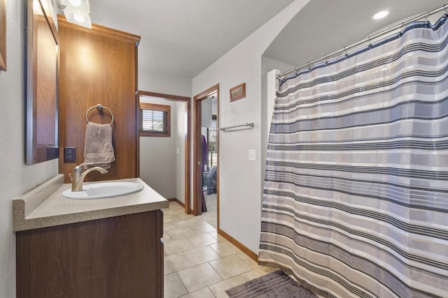 bathroom with baseboards, a shower with shower curtain, vanity, and tile patterned floors