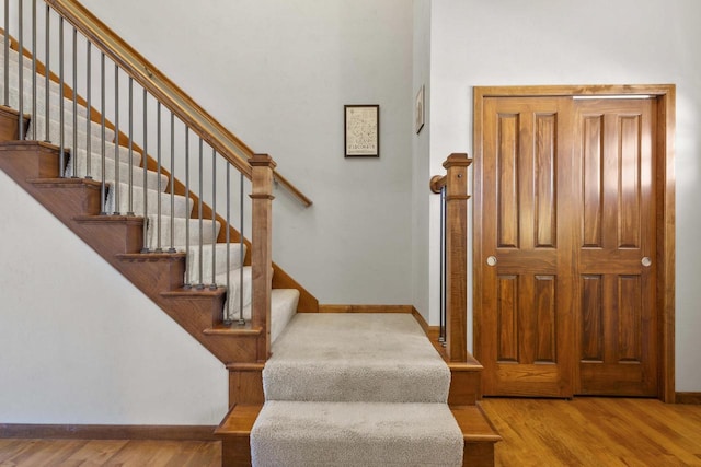 staircase featuring baseboards and wood finished floors