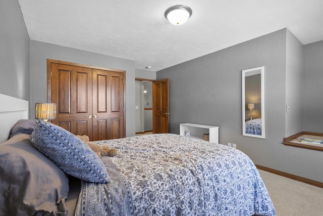 carpeted bedroom with baseboards and a closet