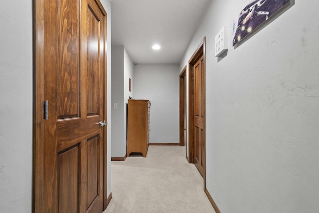 hallway with light carpet and baseboards