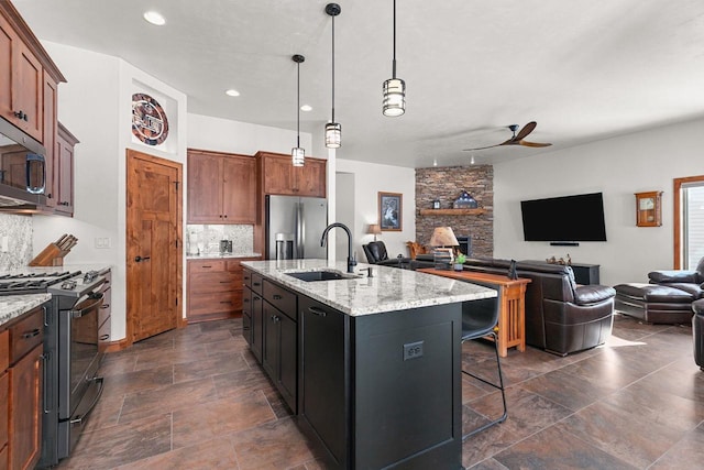 kitchen with tasteful backsplash, appliances with stainless steel finishes, open floor plan, and a sink