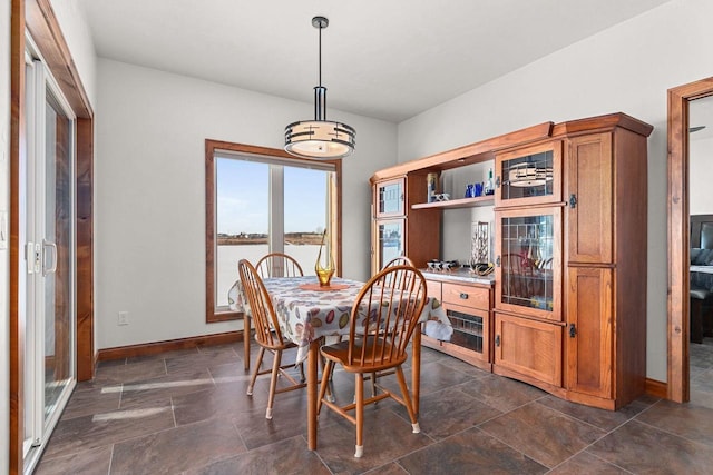 dining room with stone finish floor and baseboards