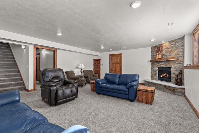 living area with a textured ceiling, a stone fireplace, carpet flooring, baseboards, and stairs