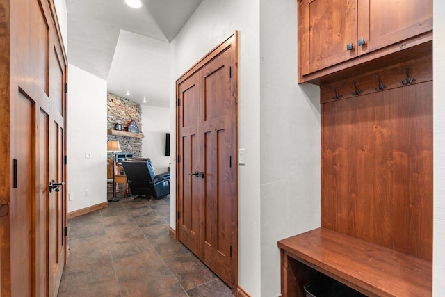 mudroom with stone finish floor and baseboards