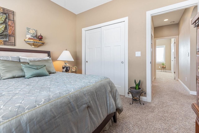 carpeted bedroom featuring baseboards and a closet