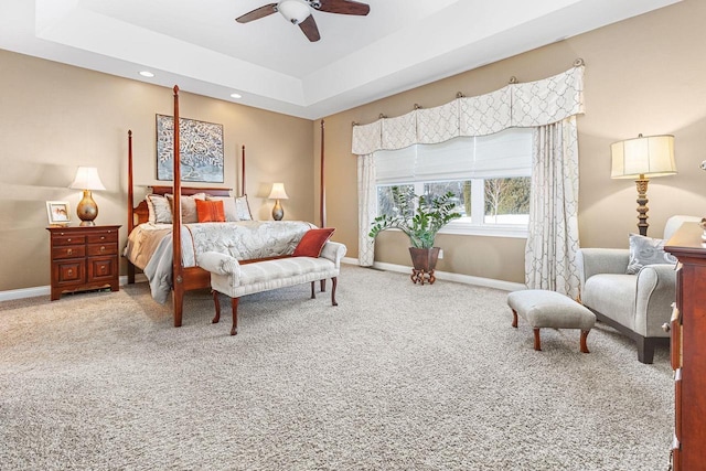 bedroom with a raised ceiling, recessed lighting, carpet flooring, and baseboards