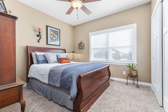 bedroom featuring light carpet, ceiling fan, and baseboards