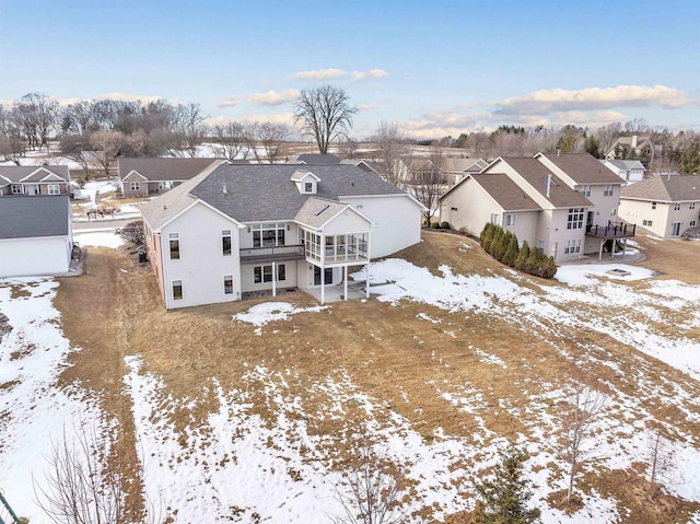 snowy aerial view with a residential view