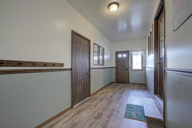 doorway with light wood-style floors and baseboards