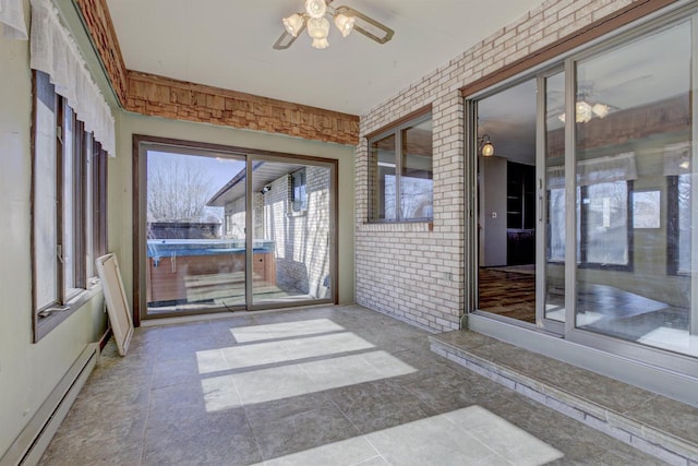 unfurnished sunroom featuring a baseboard radiator and ceiling fan