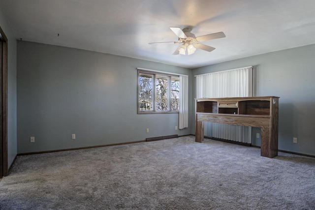 unfurnished office with a ceiling fan, baseboards, and carpet flooring