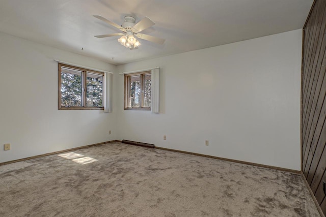 unfurnished room with carpet floors, baseboards, and a ceiling fan