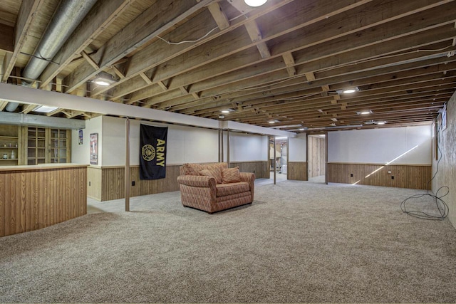 finished basement with carpet, a wainscoted wall, and wooden walls