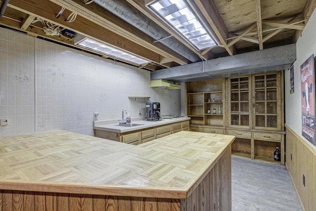 kitchen featuring wainscoting, butcher block countertops, white cooktop, open shelves, and a sink