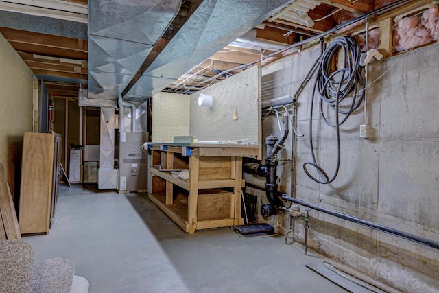 unfinished basement with heating unit and a workshop area