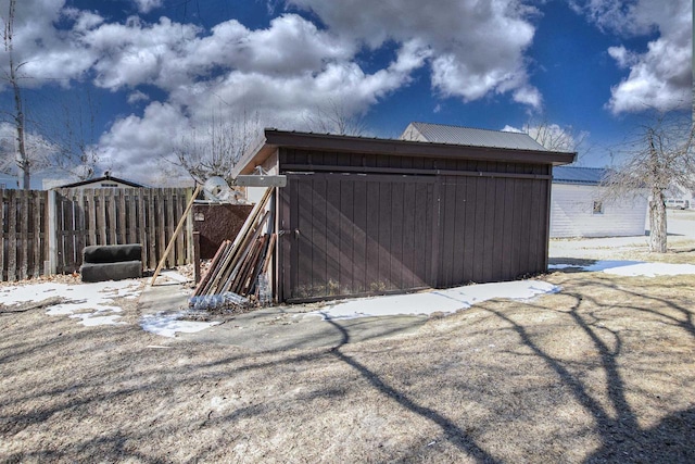 exterior space featuring fence and an outbuilding