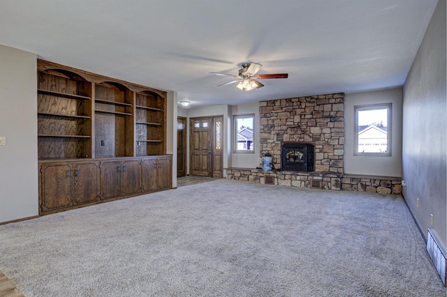 unfurnished living room with a fireplace, visible vents, a ceiling fan, carpet flooring, and baseboards