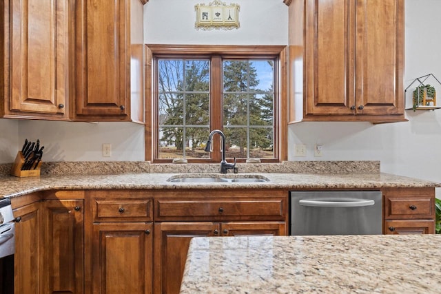 kitchen with dishwasher, a sink, and brown cabinets