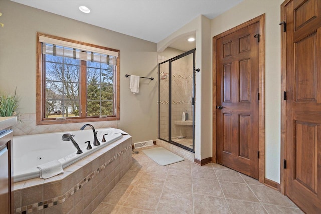 bathroom with tile patterned flooring, visible vents, baseboards, a jetted tub, and a shower stall