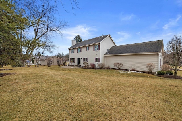 rear view of house with a lawn and a chimney