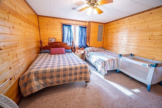 carpeted bedroom featuring wood walls and electric panel