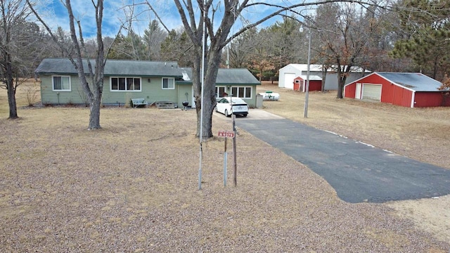 exterior space with a garage, driveway, and an outbuilding