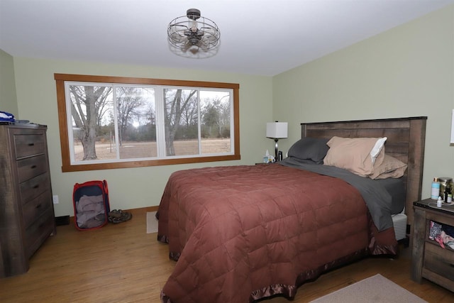 bedroom featuring baseboards and wood finished floors