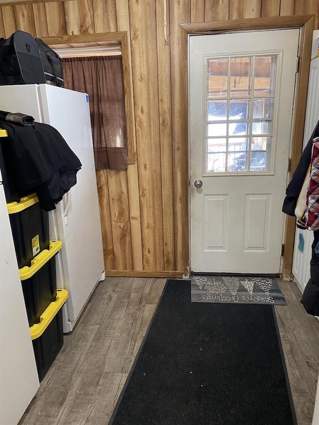 doorway to outside with wooden walls and wood finished floors