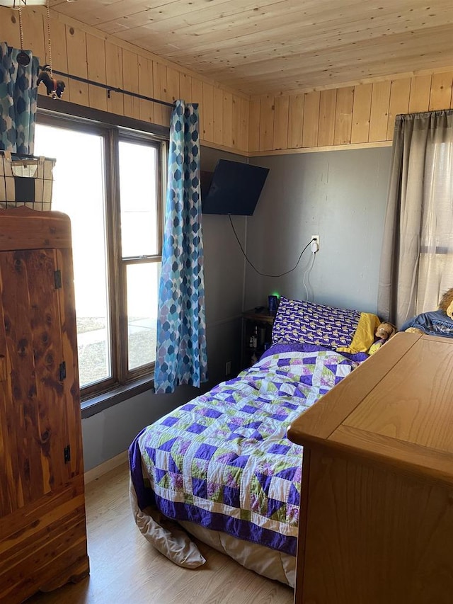 bedroom with wood walls, wood ceiling, and wood finished floors