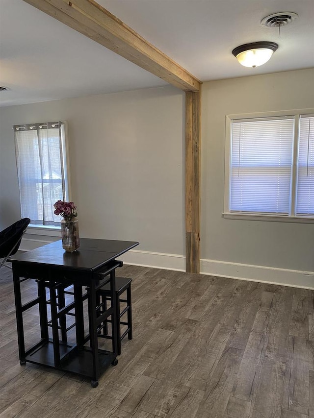 dining space featuring beamed ceiling, wood finished floors, and visible vents