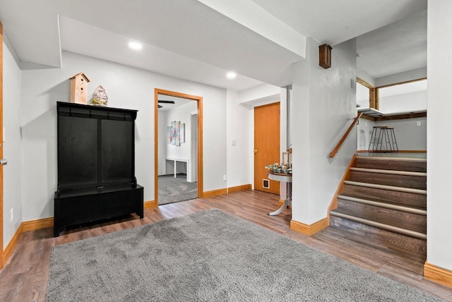 unfurnished living room featuring baseboards, stairway, wood finished floors, and recessed lighting