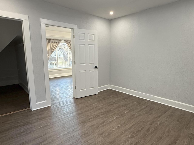 spare room featuring dark wood-style floors, recessed lighting, and baseboards