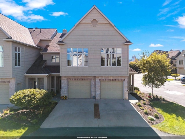 view of front of property with a garage, stone siding, and concrete driveway