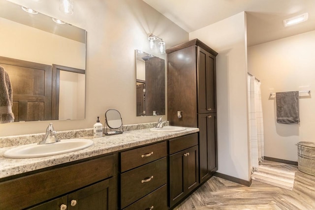 bathroom featuring double vanity, curtained shower, and a sink