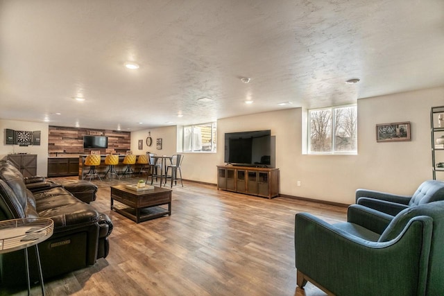 living room with light wood-type flooring, a healthy amount of sunlight, baseboards, and recessed lighting