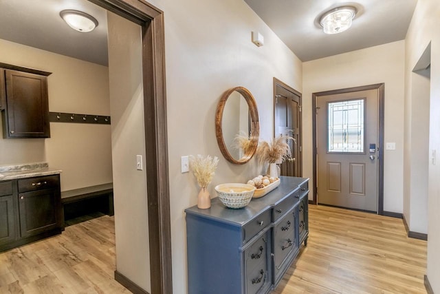 doorway featuring light wood-type flooring and baseboards