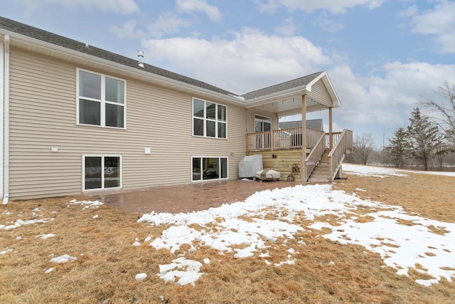 snow covered property with stairway