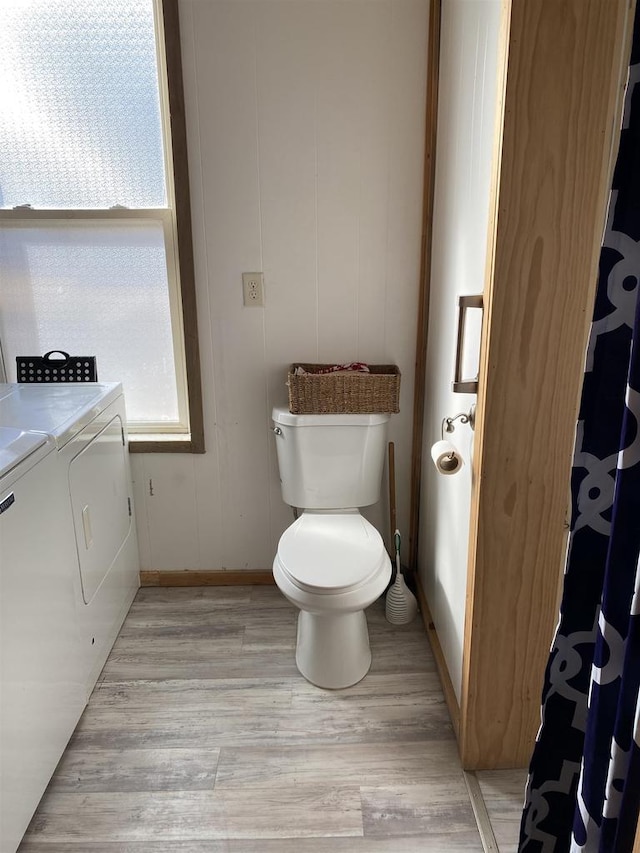 full bathroom with toilet, baseboards, wood finished floors, and washing machine and clothes dryer