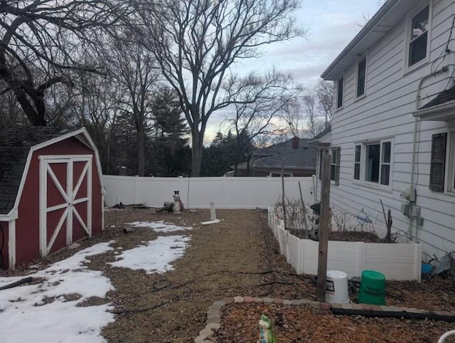 view of yard featuring an outbuilding, a garden, fence, and a storage shed